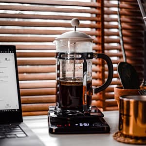 clear glass mug on black and silver laptop computer