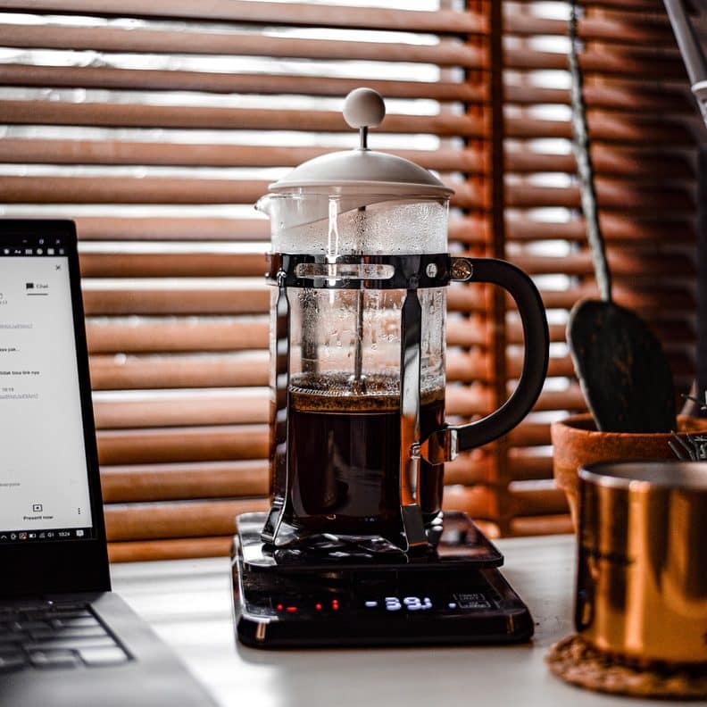 clear glass mug on black and silver laptop computer
